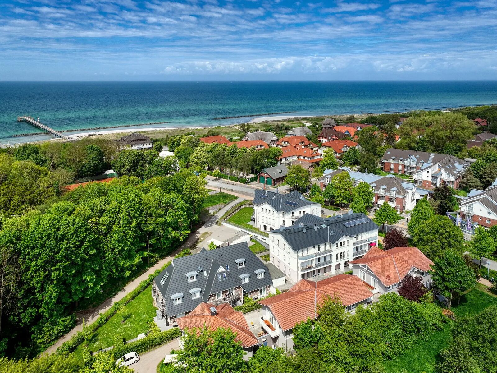 Een kustgebied met huizen, een pier en een strand.