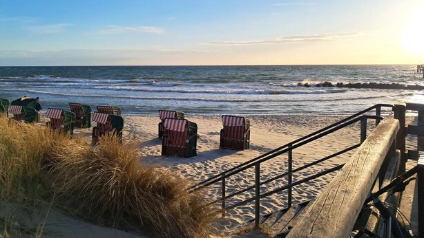 A beach with chairs and a wooden walkway leading to the ocean. - Seebrücke Vacation Rental – Stay Close to the Beach with a Guarantee of Comfort (Wustrow)