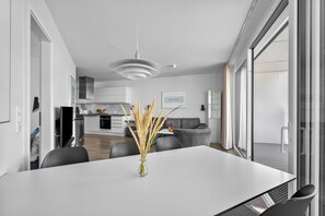 Eine moderne Küche mit weißen Schränken, einem eingebauten Backofen und einer Edelstahl-Dunstabzugshaube.