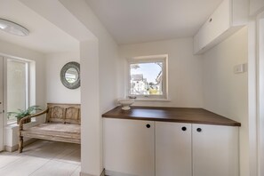 Eine Küche mit Fenster, einer Holzbank und einem Spiegel an der Wand.