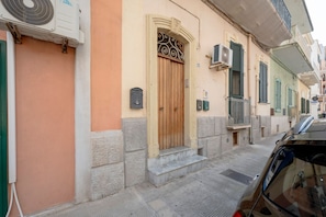 A building with a wooden door, air conditioning units, and a mailbox. - GuestHost - Colourful Monopoli Apartment (Monopoli)
