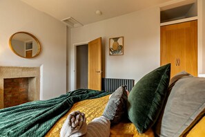 A bedroom with a bed, a fireplace, a mirror, and a wardrobe. - 1 Bed in Crich (oc-h37533) (Crich)