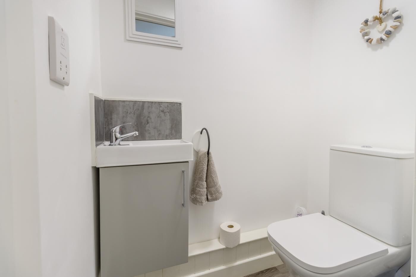 A bathroom with a toilet, sink, and towel rack.