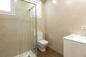 A bathroom with a glass shower enclosure, a toilet, and a sink. - 31agrvc1136  lovely flat in the city centre (Barcelona)