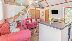 A cozy interior with a wooden ceiling, a pink sofa set, a kitchen area, and a staircase. - 2 Bed in Hexham (oc-92527) (Catton)