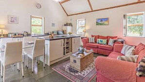A spacious kitchen with a dining area, a red sofa, and a wooden coffee table. - 2 Bed in Hexham (oc-92527) (Catton)