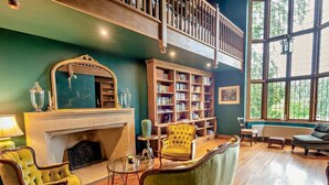 Eine Bibliothek mit Bücherregalen, einem Kamin und einem Balkon.