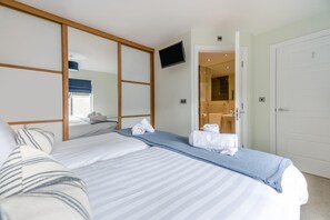 A hotel room with a bed, a TV mounted on the wall, and a bathroom visible through an open door. - 2 Bed in Seahouses (oc-p39046) (Seahouses)