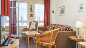 A living room with a sofa, chairs, a table, a TV, and a lamp. - Schone Ferienwohnung fur 4 Personen Ostseenah in Sellin (Sellin)