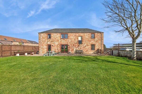 A stone building with a green lawn in front. - 5 Bed in Cockburnspath (oc-r35051) (Cockburnspath)