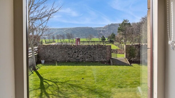 A stone wall, a grassy yard, and a view of distant hills. - 5 Bed in Cockburnspath (oc-r35051) (Cockburnspath)