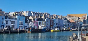 Um porto com edifícios coloridos e barcos atracados.