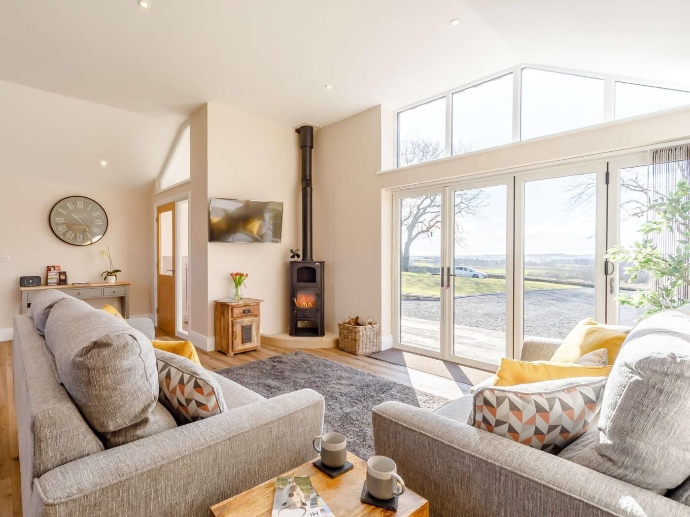 A living room with a fireplace, sofas, a coffee table, and a large window with a view.