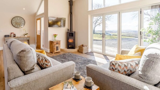 Ein Wohnzimmer mit Kamin, Sofas, einem Couchtisch und einem großen Fenster mit Blick.