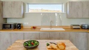 Eine moderne Küche mit Oberlicht, Mikrowelle, Toaster und Spüle.