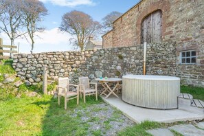 A stone wall, wooden chairs, a table, and a hot tub in an outdoor setting. - 1 Bed in Ponsonby (oc-l37879) (Ponsonby)