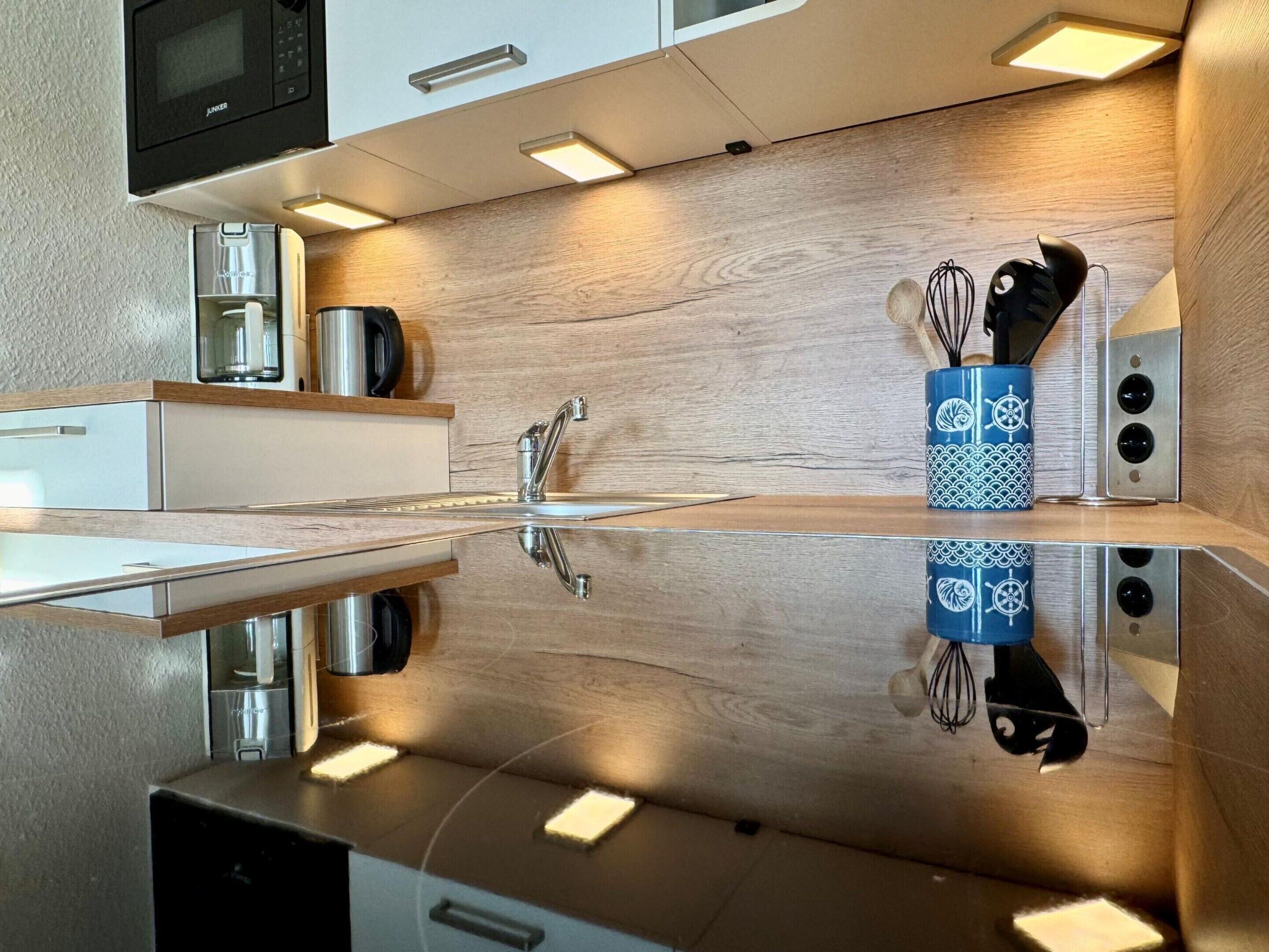 A modern kitchen with a stainless steel sink, a microwave, and a coffee maker.
