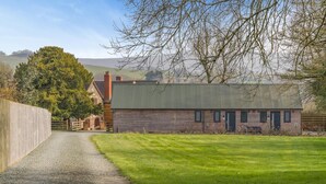 A rural property with a gravel driveway, a wooden barn, and a grassy field. - 1 Bed in Minsterley (oc-s38642) (Minsterley)