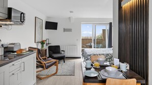 A modern kitchen with a toaster, a chair, and a dining area set for breakfast. - 1 Bed in Minsterley (oc-s38642) (Minsterley)