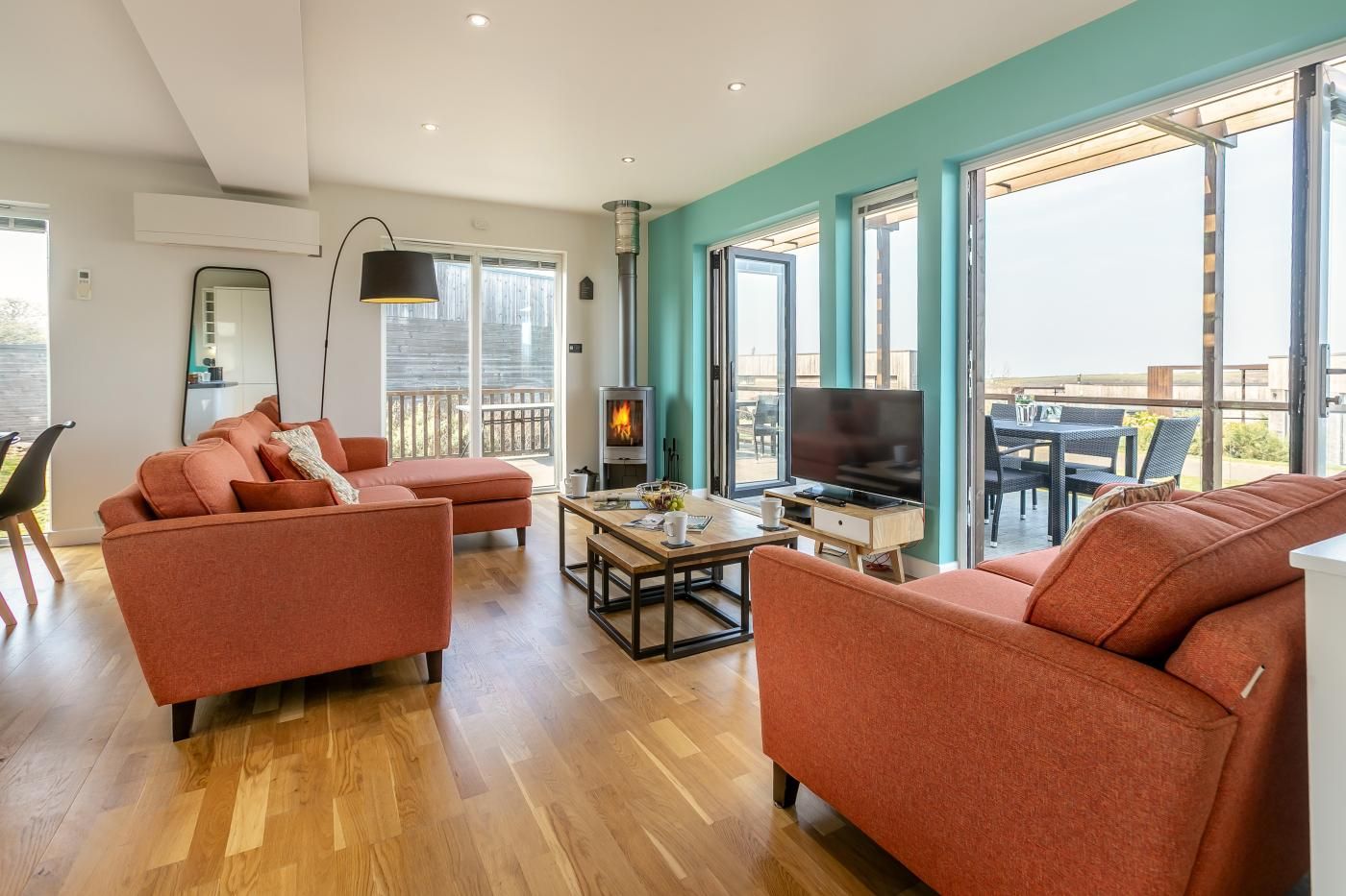 Ein modernes Wohnzimmer mit Kamin, zwei Sofas, einem Couchtisch und einem Fernseher.