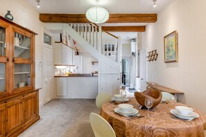 A dining area with a table set for four, a staircase, and a wooden cabinet with glass doors. - 2 Bed in Battle (oc-sx913) (Battle)