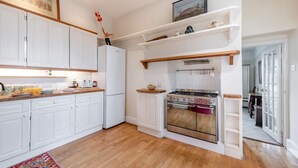 Una cocina con armarios blancos, estufa y refrigerador.