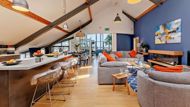 A modern interior with a kitchen, seating area, and high ceilings. - 2 Bed in Borth (oc-ystiw4) (Glanwern)