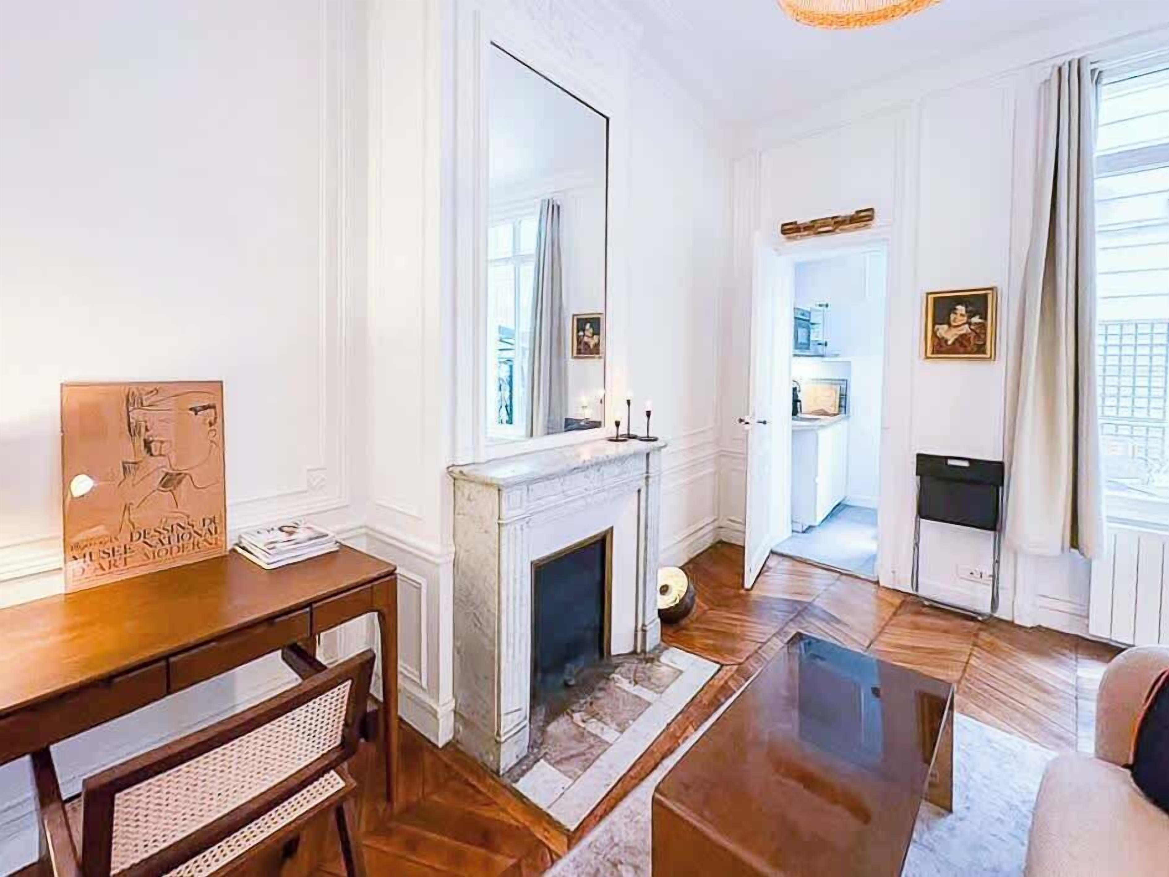 A living room with a fireplace, a wooden coffee table, a sofa, and a dining table.