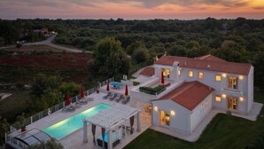 A modern villa with a swimming pool, outdoor seating, and a view of the surrounding landscape. - Casa Andrik - Five Bedroom Villa, Sleeps 12 (Režanci)