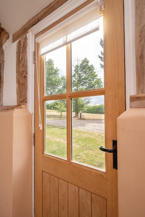 Eine Holztür mit Fenster, einem schwarzen Türgriff und einem weißen Türrahmen.