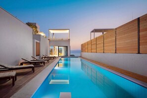 A modern pool area with lounge chairs, a clear pool, and a wooden wall. - Villa Etesia - Three Bedroom Villa, Sleeps 6 (Marušići)