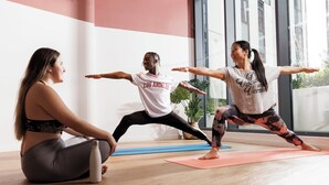 Three people practicing yoga in a room with large windows and a plant. - Students Only - Unite Parkway - Manchester (Manchester)