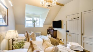 A bedroom with a bed, bedside lamp, dresser, TV, window, and a door. - 2 Bed in Glenshee (oc-l37493) (Spittal of Glenshee)