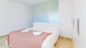 Een moderne hotelkamer met een bed, een groot raam en een wandgemonteerde airconditioning.