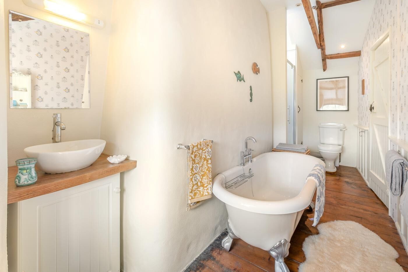 Een badkamer met een vrijstaand bad, een wastafel en een toilet.