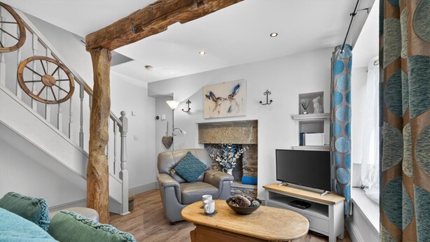 A modern living room with a staircase, a fireplace, a TV, and a dining area. - 2 Bed in Hawes (oc-c38234) (Hawes)