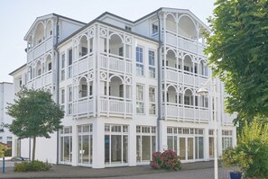A multi-story building with balconies, large windows, and a brick-paved entrance. - Geschmackvoll Eingerichtete Ferienwohnung mit Grossem Balkon in Sellin (Sellin)