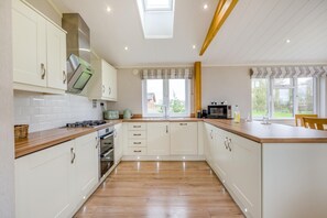 A modern kitchen with white cabinets, a wooden countertop, and a built-in oven. - 2 Bed in Athelington (oc-d35071) (Athelington)