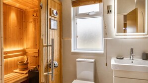 A wooden sauna with a glass door, a toilet, and a sink with a mirror. - 2 Bed in Athelington (oc-d35071) (Athelington)