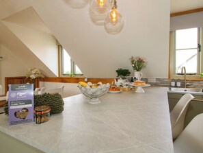 Una cocina con una isla grande, comedor y vistas al exterior.