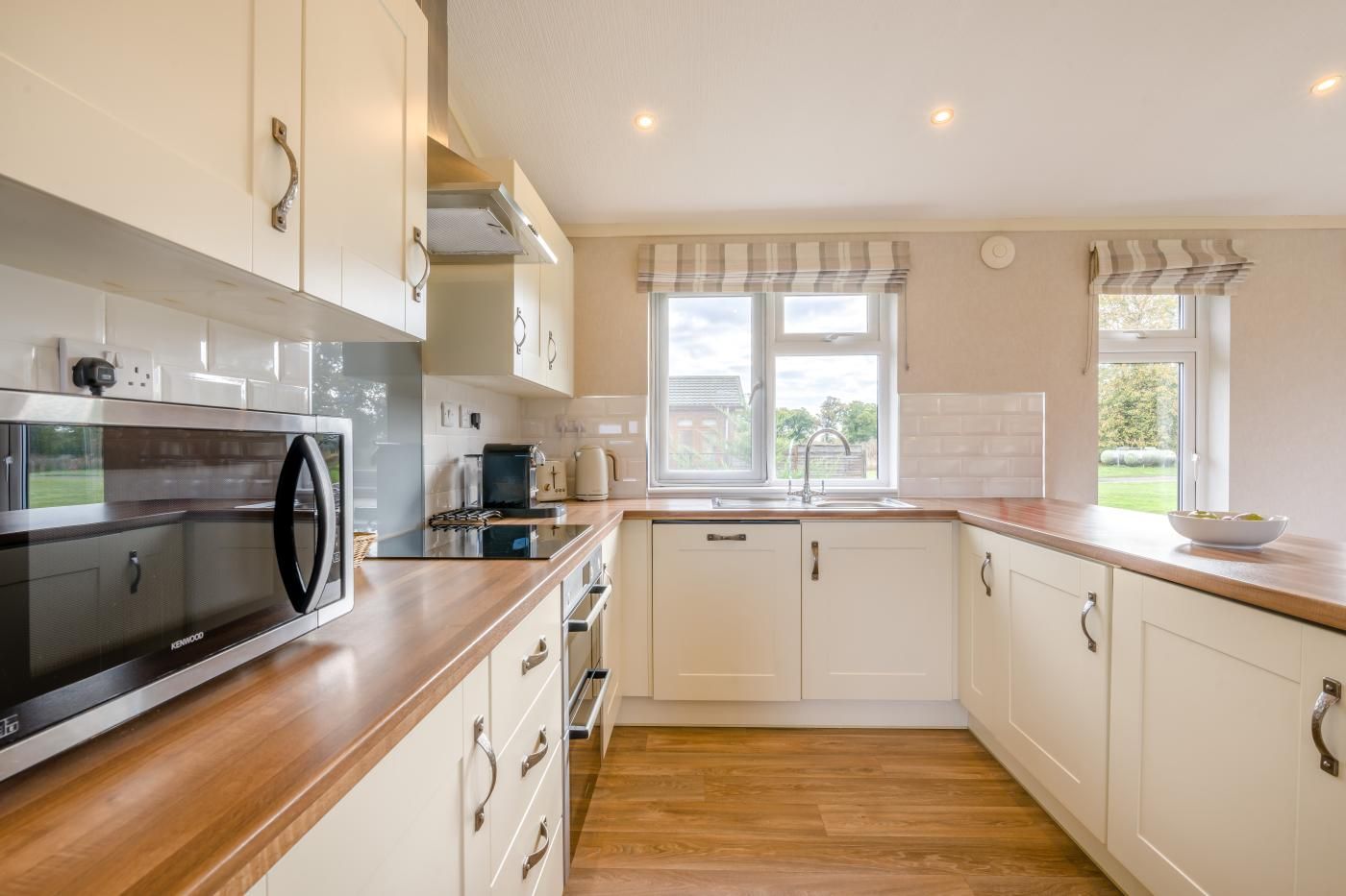 A modern kitchen with a built-in microwave, a kettle, and a sink.