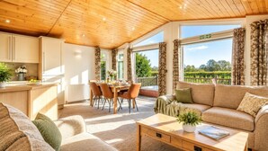 Ein gemütliches Wohnzimmer mit einer Couch, einem Couchtisch und einem Essbereich mit Stühlen und einem Tisch.