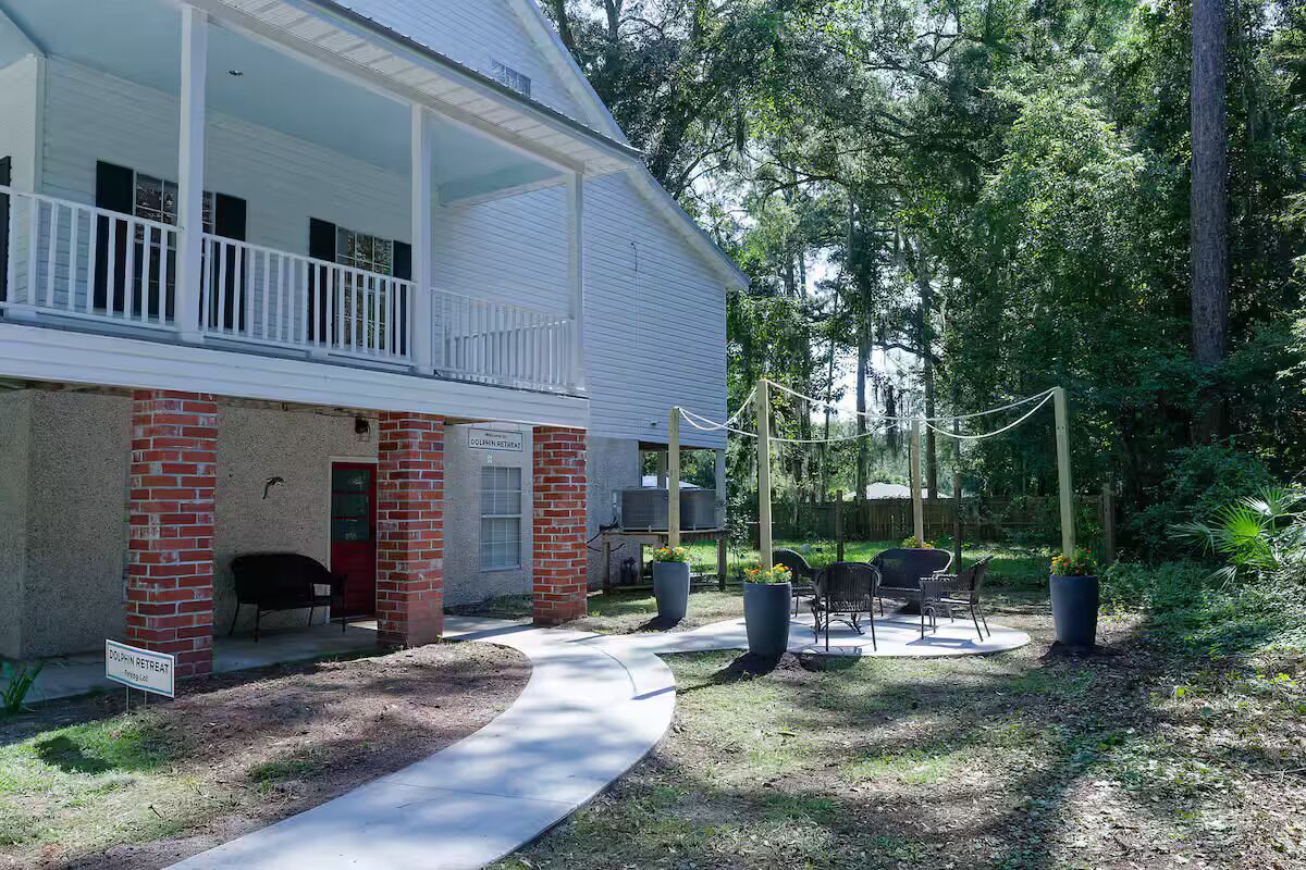 A building with a porch, outdoor seating, and a sign indicating a retreat.