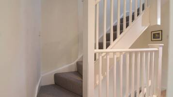 A staircase with white railings and carpeted steps.