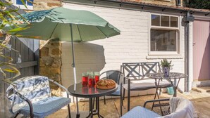 A patio with outdoor furniture, a table, and a green umbrella. - 2 Bed in Ampleforth (oc-c37505) (Ampleforth)