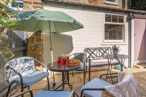 A patio with outdoor furniture, a table, and a green umbrella. - 2 Bed in Ampleforth (oc-c37505) (Ampleforth)