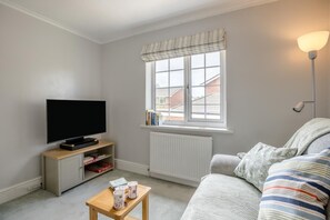A living room with a television, a radiator, a window with a view, a lamp, and a sofa. - 1 Bed in Woodbury (oc-w37536) (Woodbury)