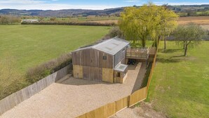 Un bâtiment d’un seul étage, doté d’un toit en pente, d’un espace extérieur couvert et d’une allée gravillonnée.