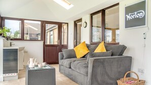 Ein modernes Wohnzimmer mit einem grauen Sofa, einem kleinen Couchtisch und einem Korbwäscheschrank.