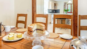 Una mesa con pastel, cupcakes y una tetera.